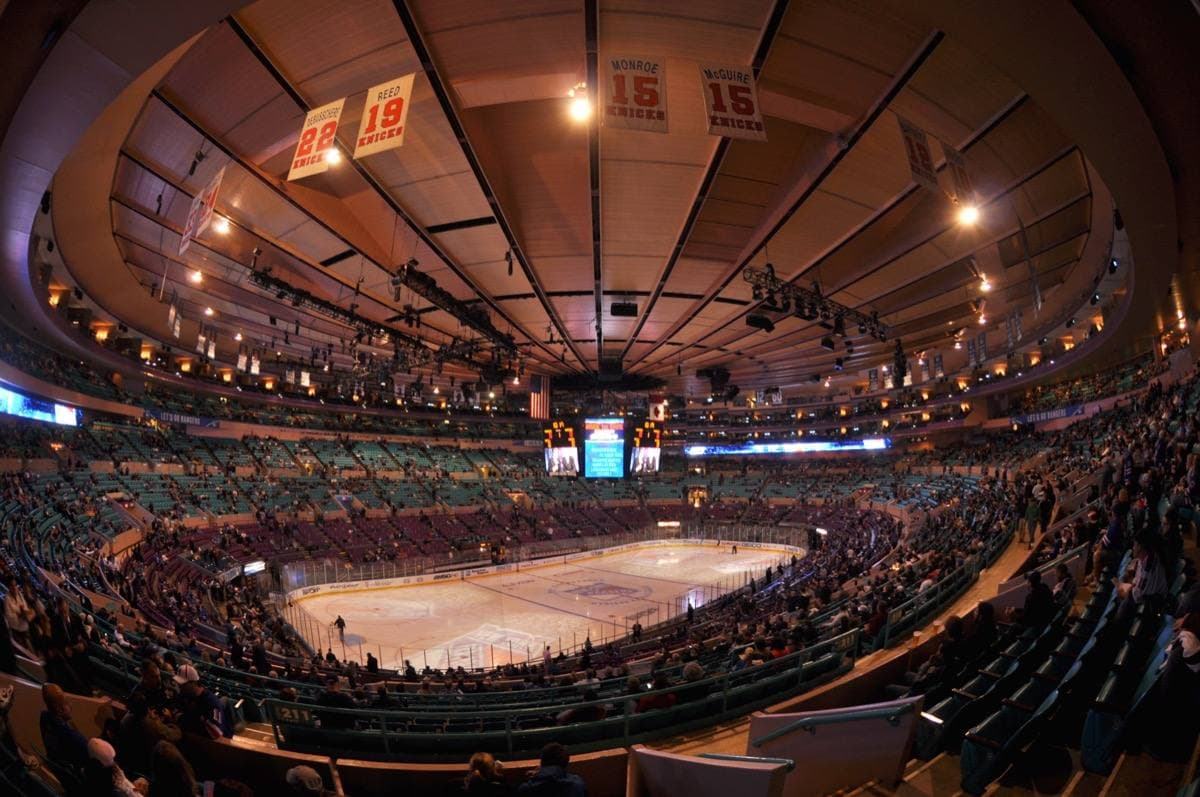 The bowl of an indoor arena under a round lit ceiling