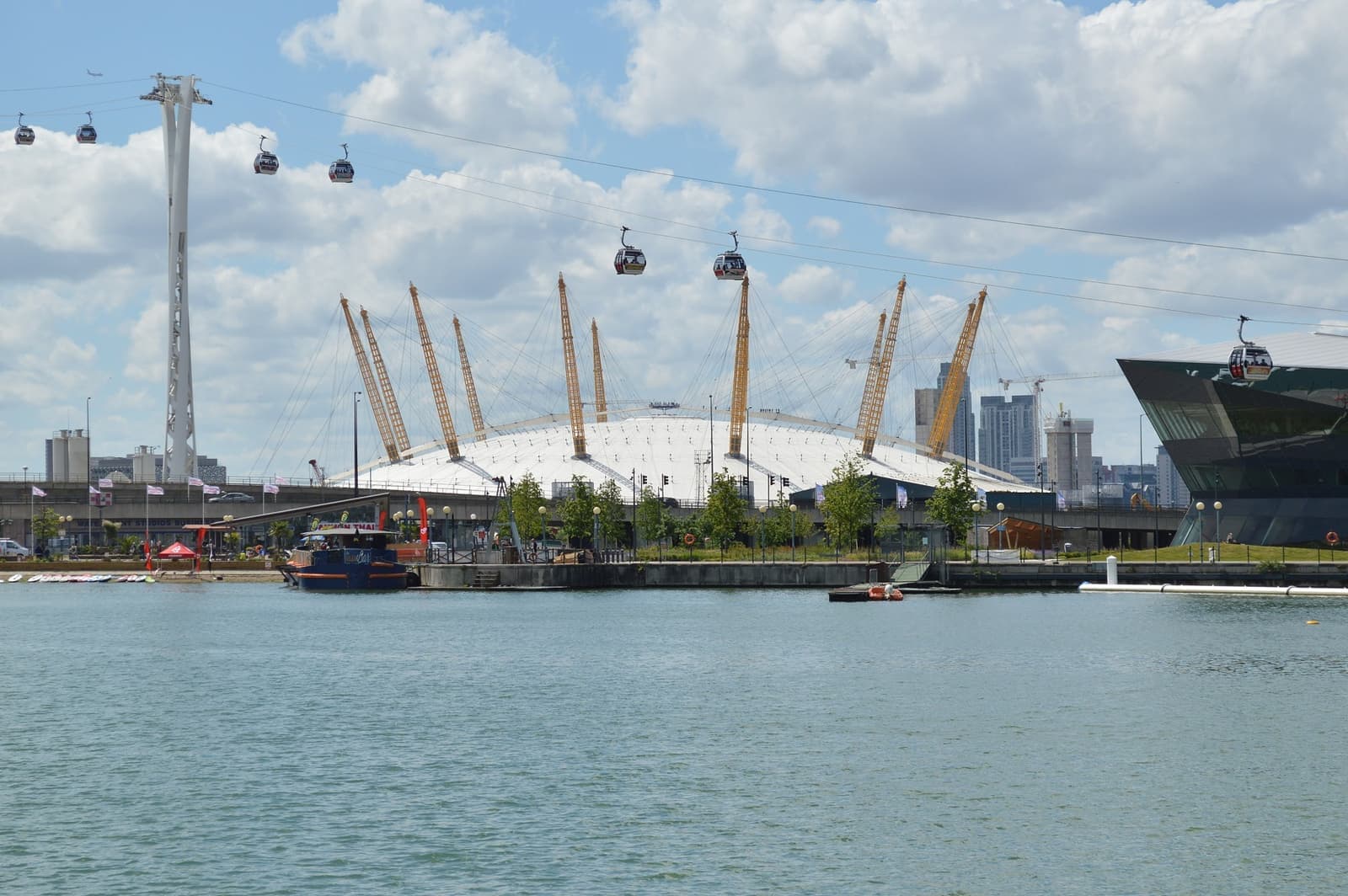 The white tented dome of the O2 with its yellow masts beside the Thames