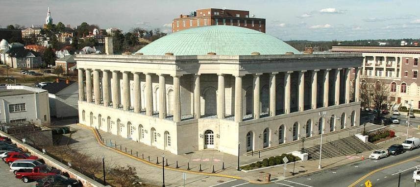A colonnaded civic auditorium with a broad green copper dome