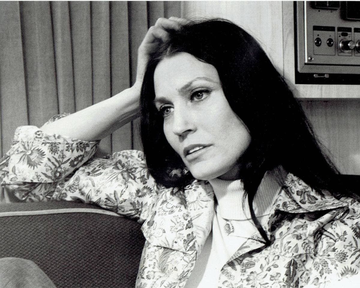 Loretta Lynn in 1975, long dark hair, talking to an interviewer