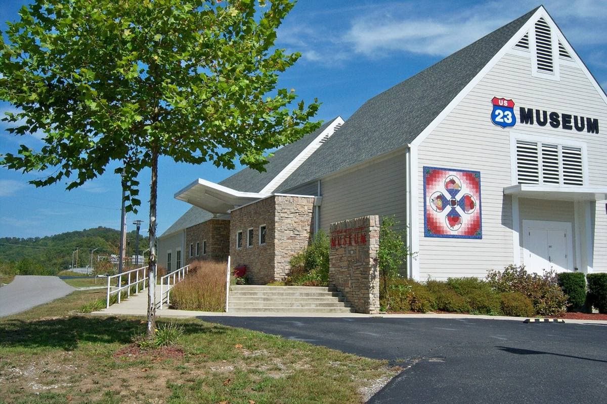 A modern brick museum building with a covered entrance