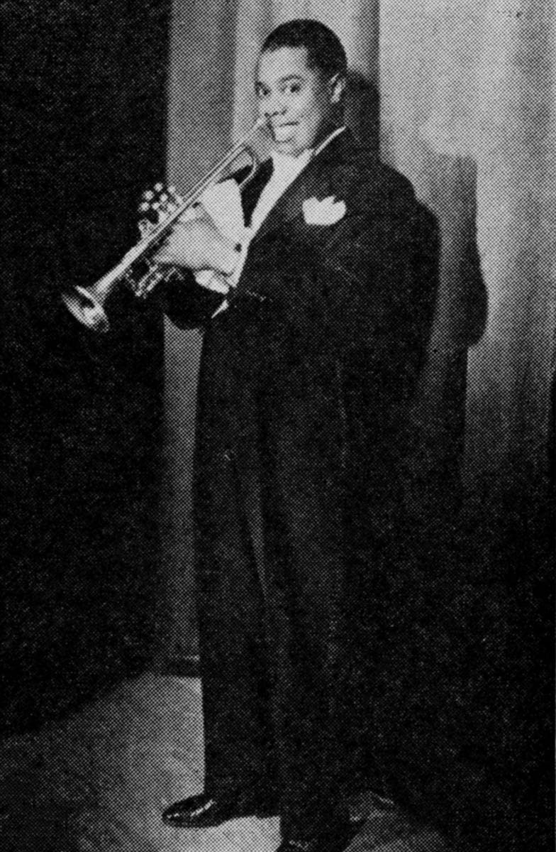Louis Armstrong in a tailcoat, trumpet raised, smiling at the camera