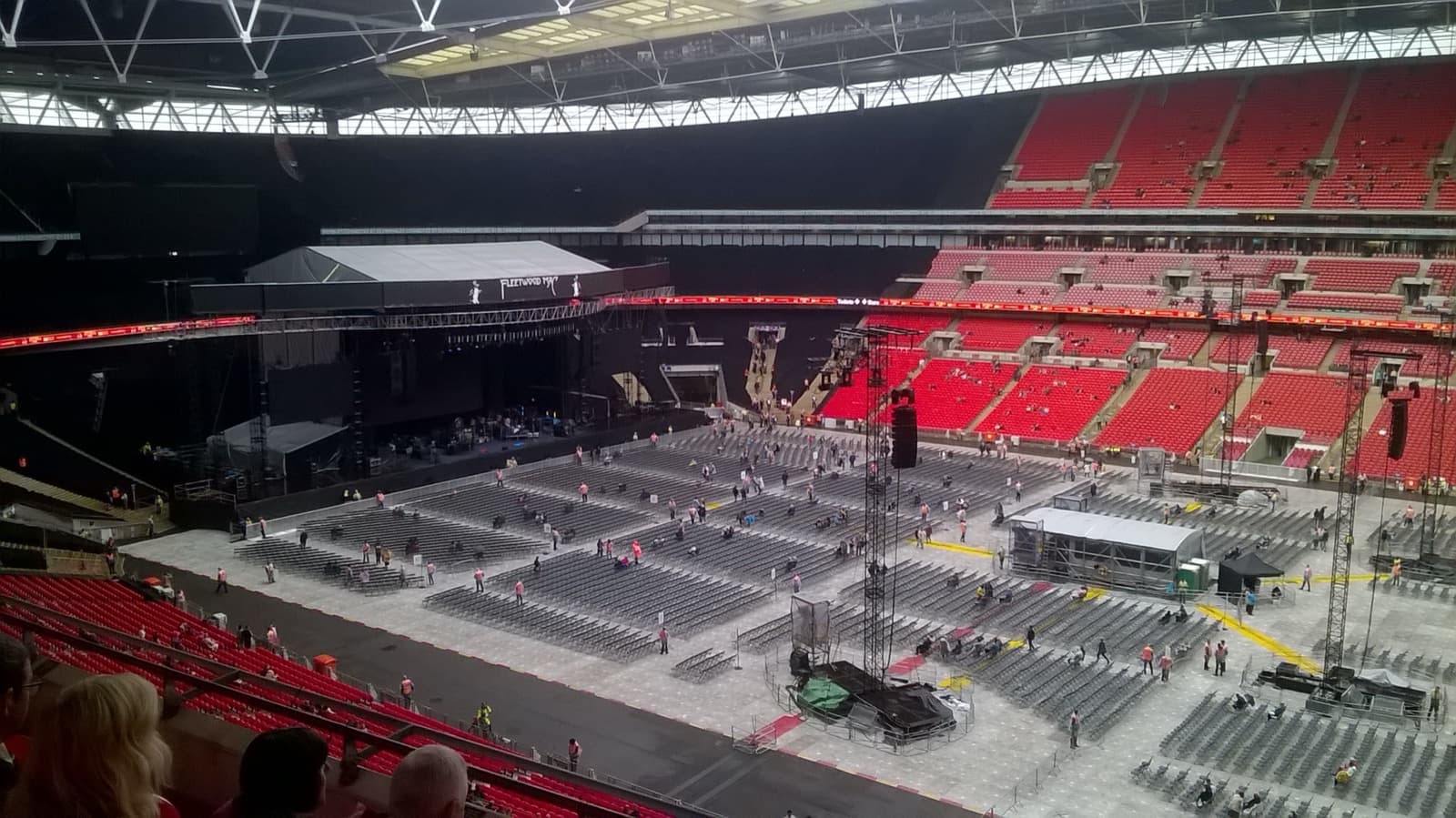 A concert stage and rows of seats on the pitch at Wembley Stadium