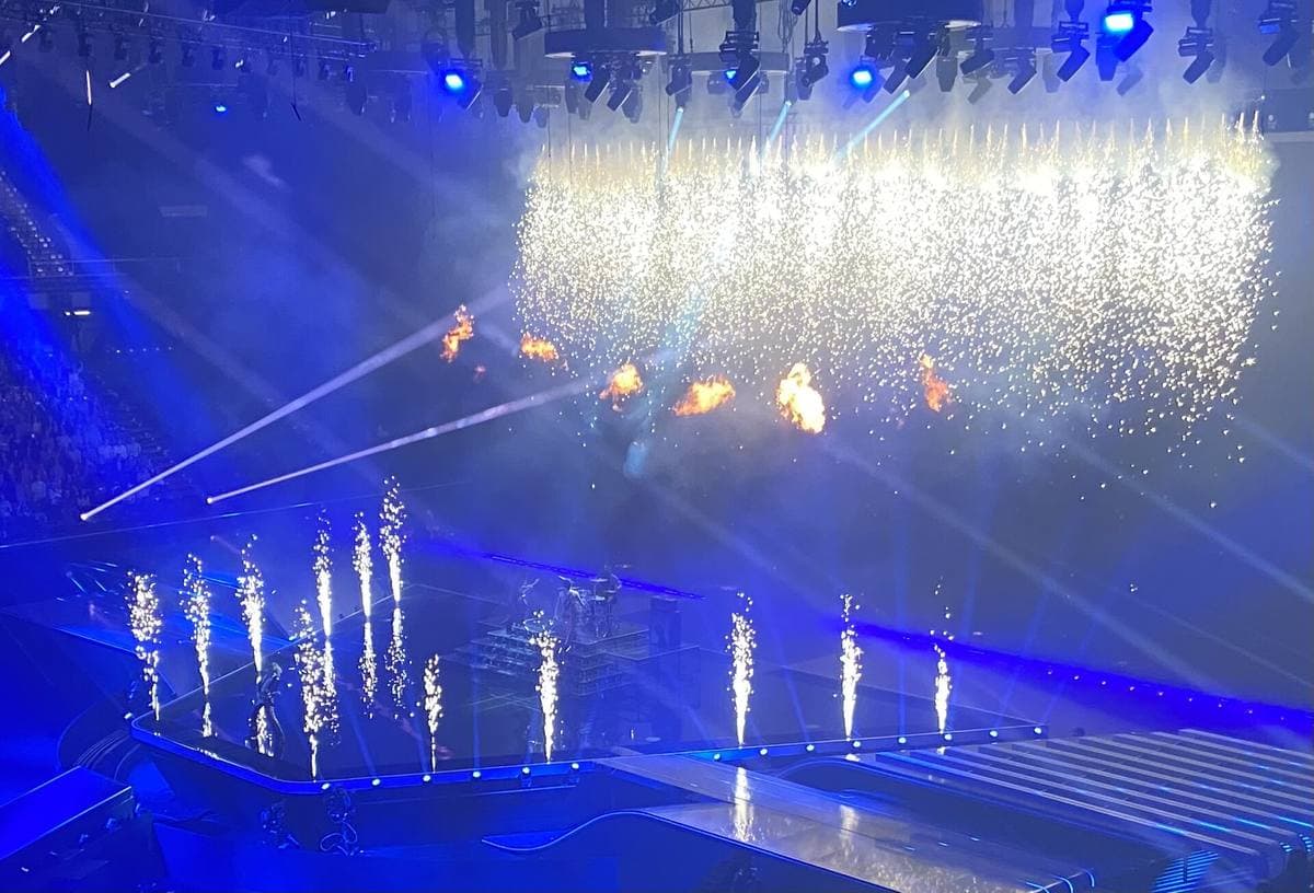 A huge arena stage washed in blue light, with fountains of sparks and flames as the band plays