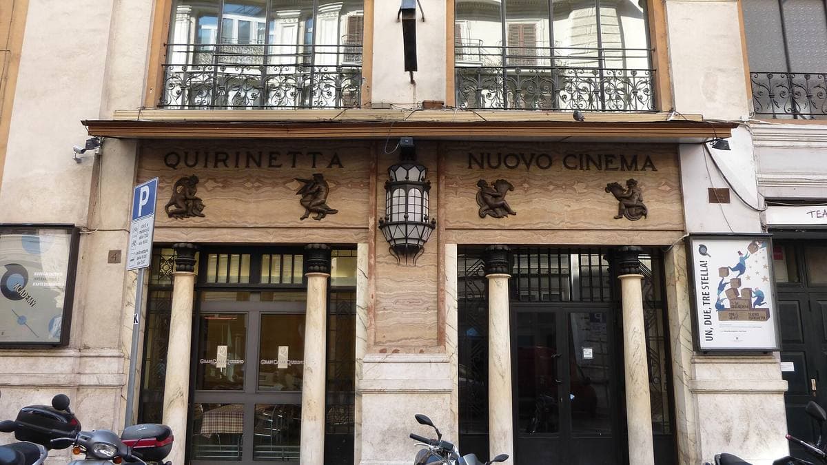 A stone entrance with columns and lanterns, the Quirinetta’s name carved over the doors