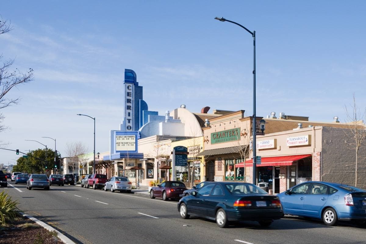 A small-town avenue with the marquee of a 1930s cinema
