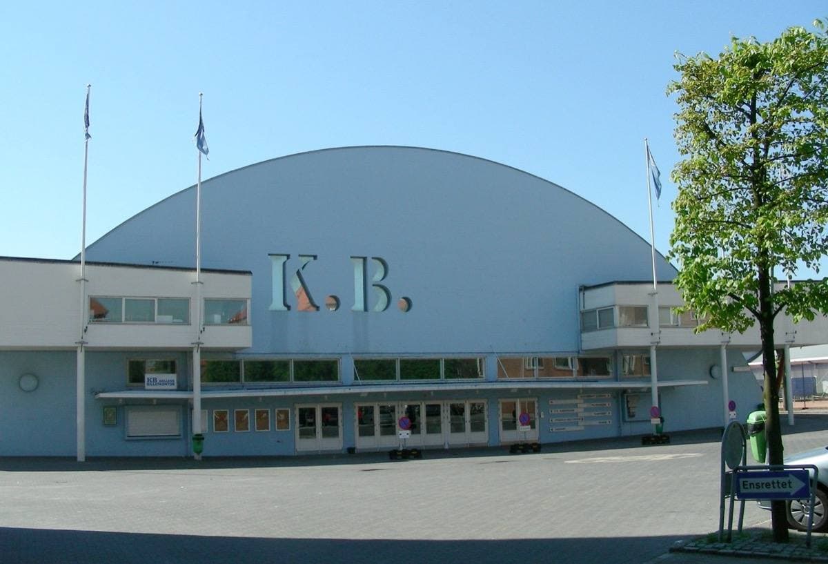 An older arched concert hall with a brick and glass front
