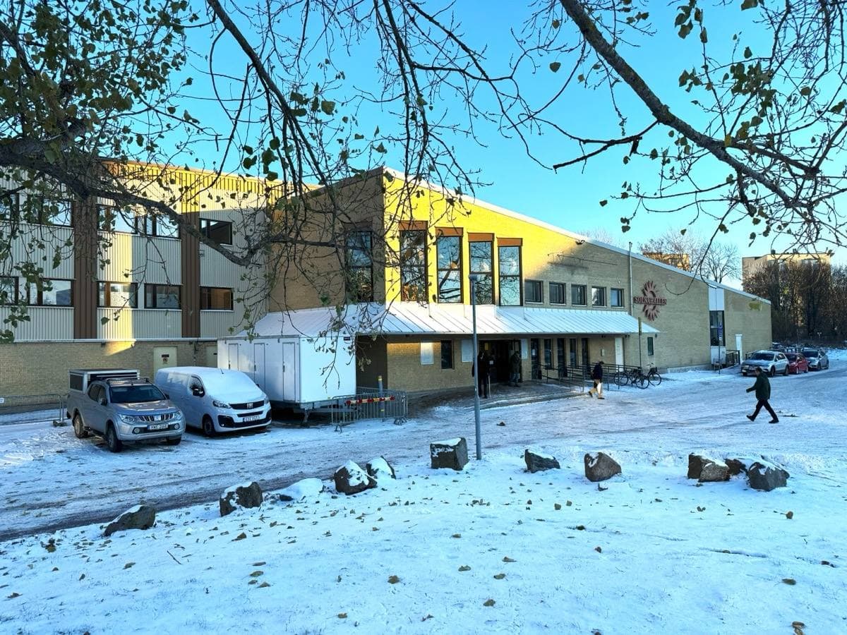 A plain brick sports hall in Solna under a grey November sky
