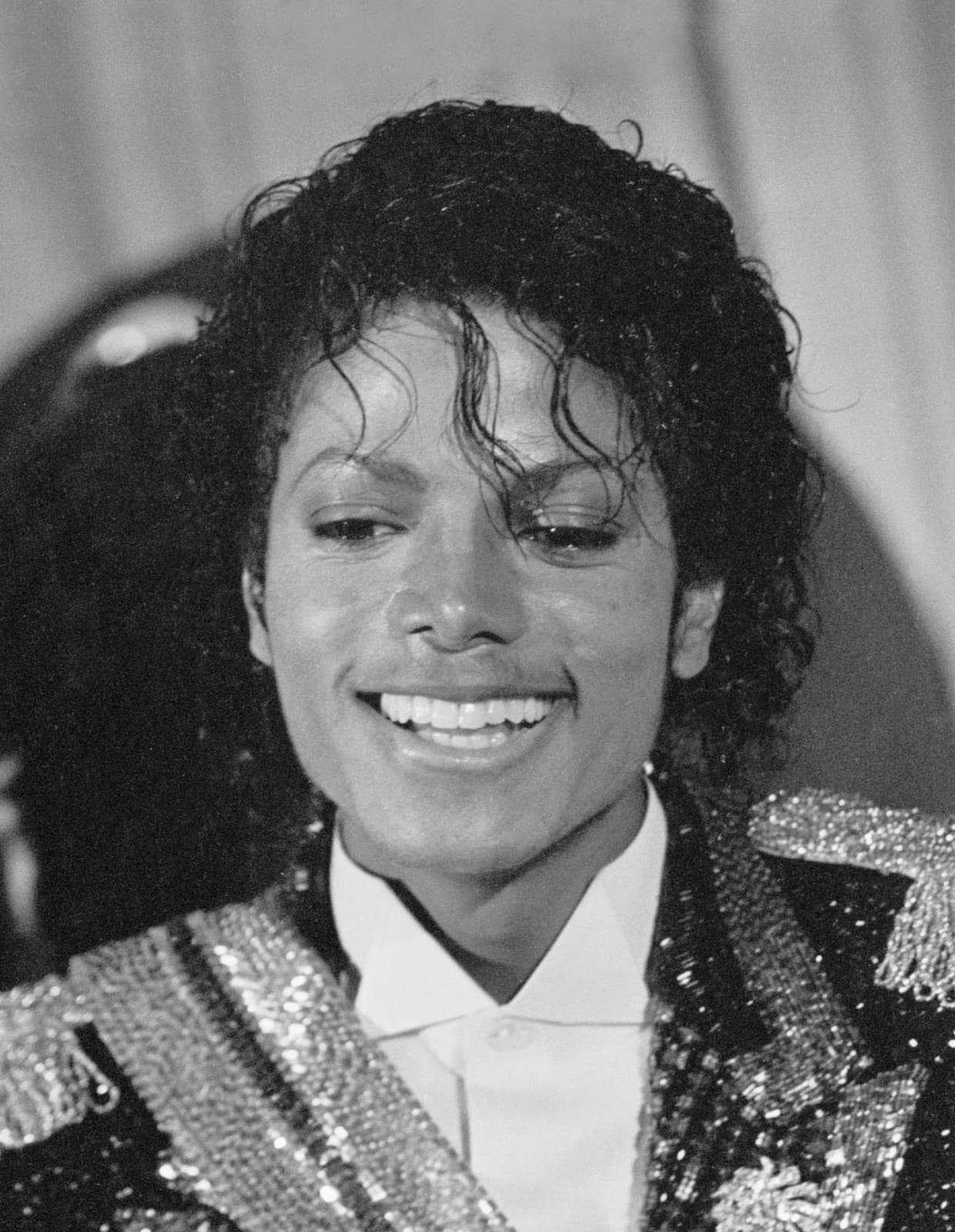 Michael Jackson smiling in a sequinned jacket, black and white