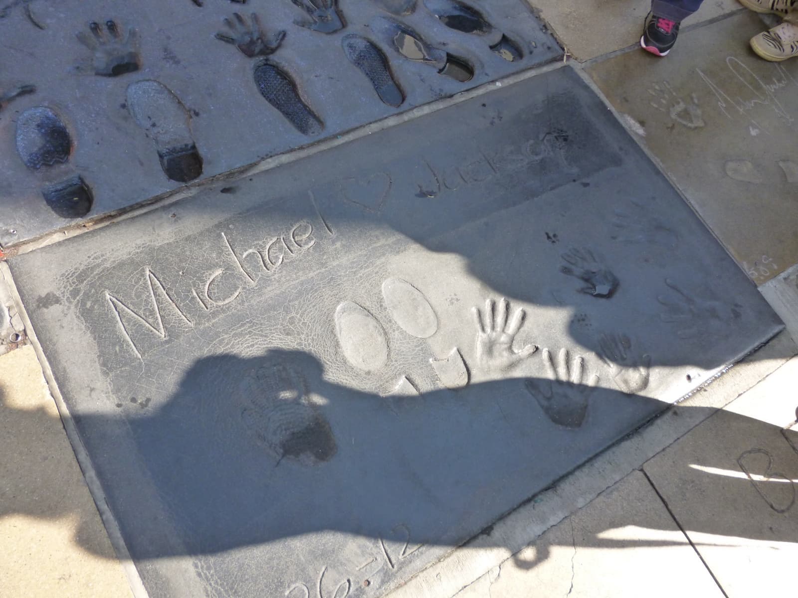 A cement slab with his signature, shoe prints, small handprints and the print of a glove