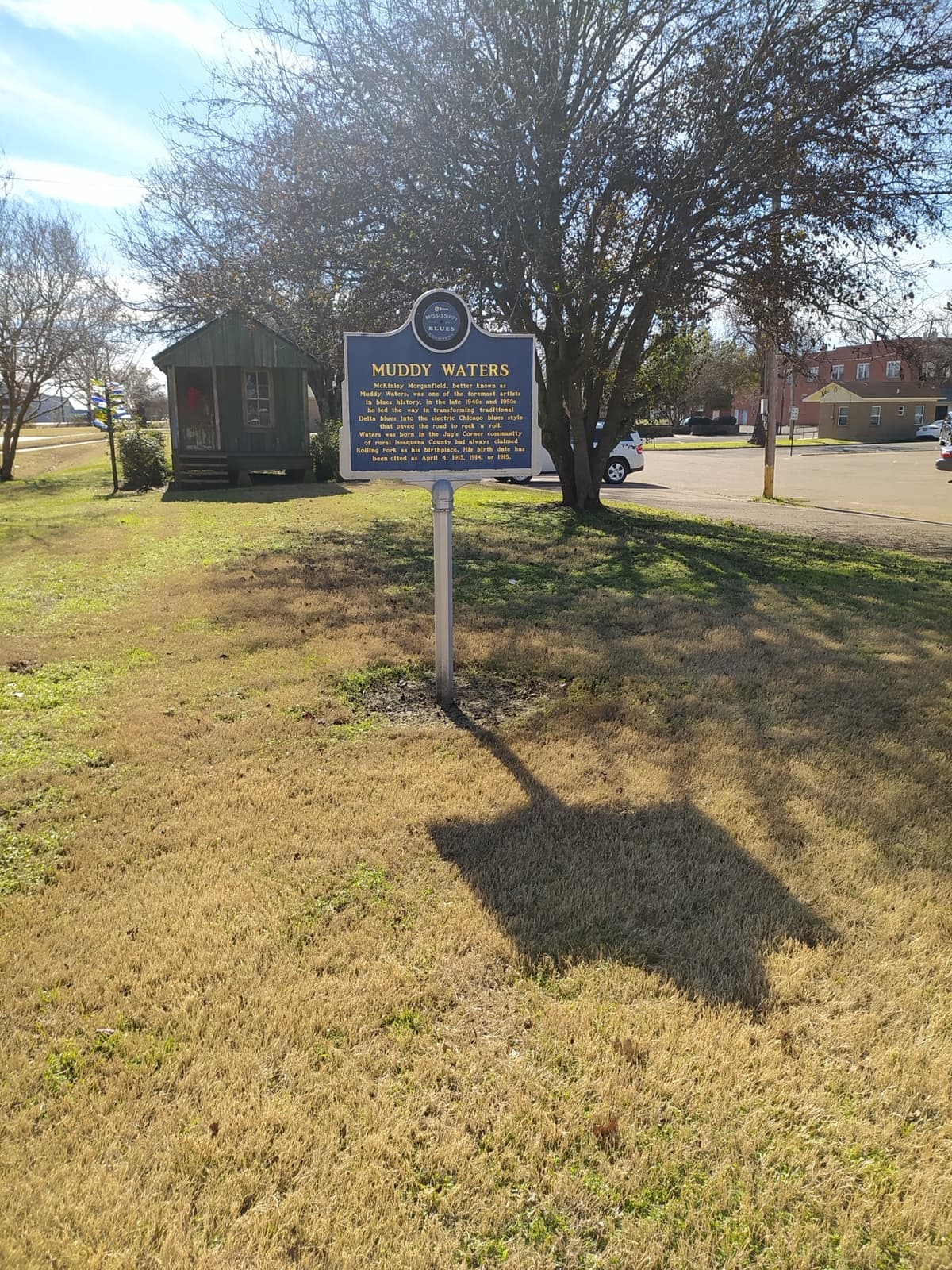 A blue Mississippi Blues Trail marker for Muddy Waters on a Rolling Fork street