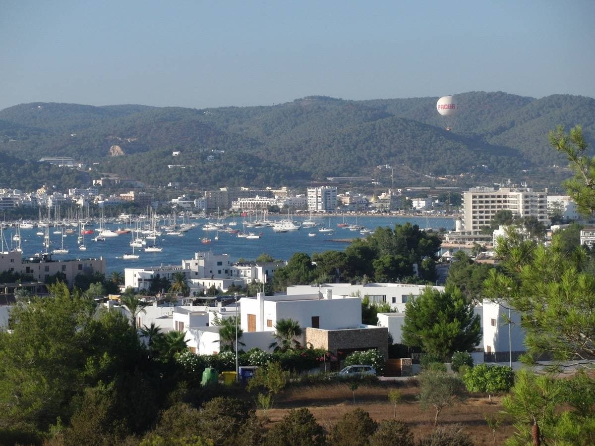 A blue bay with white buildings along its shore