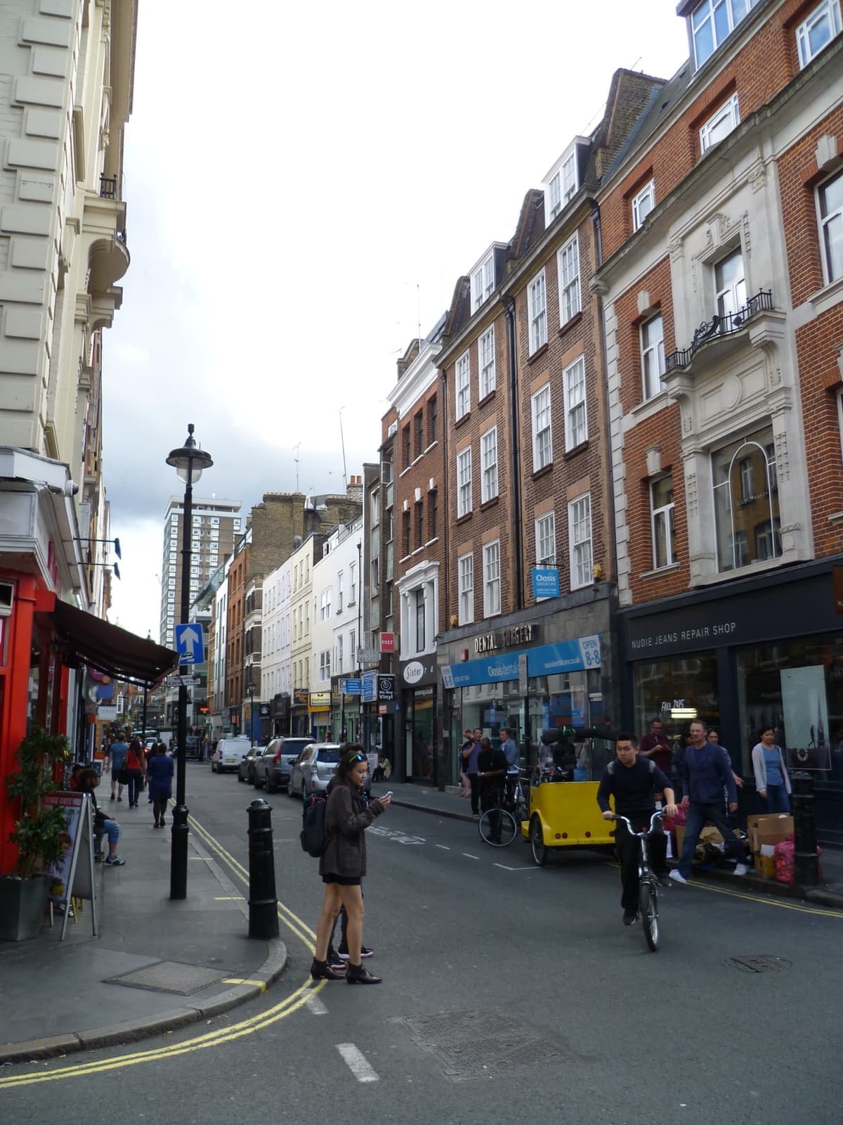 A narrow Soho street of shops looking along its length