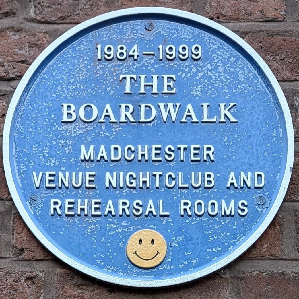 A round plaque for the Boardwalk on a brick wall