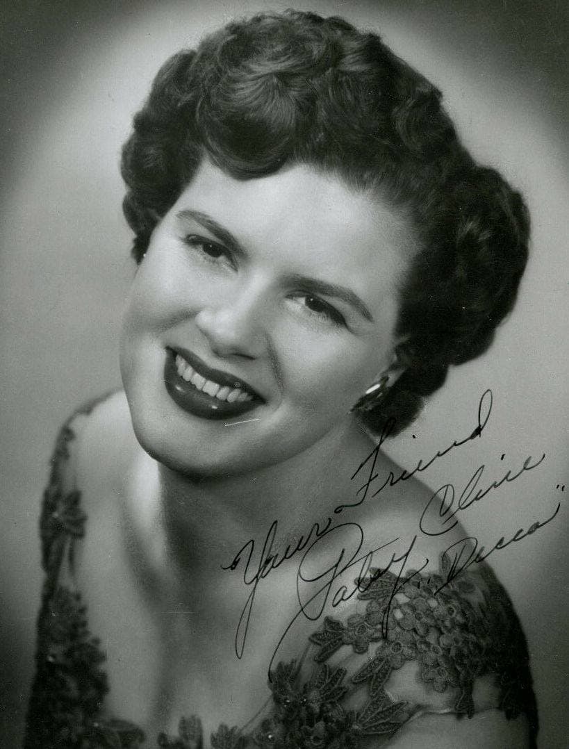 Patsy Cline smiling over her shoulder in a lace dress, a signature written across the corner