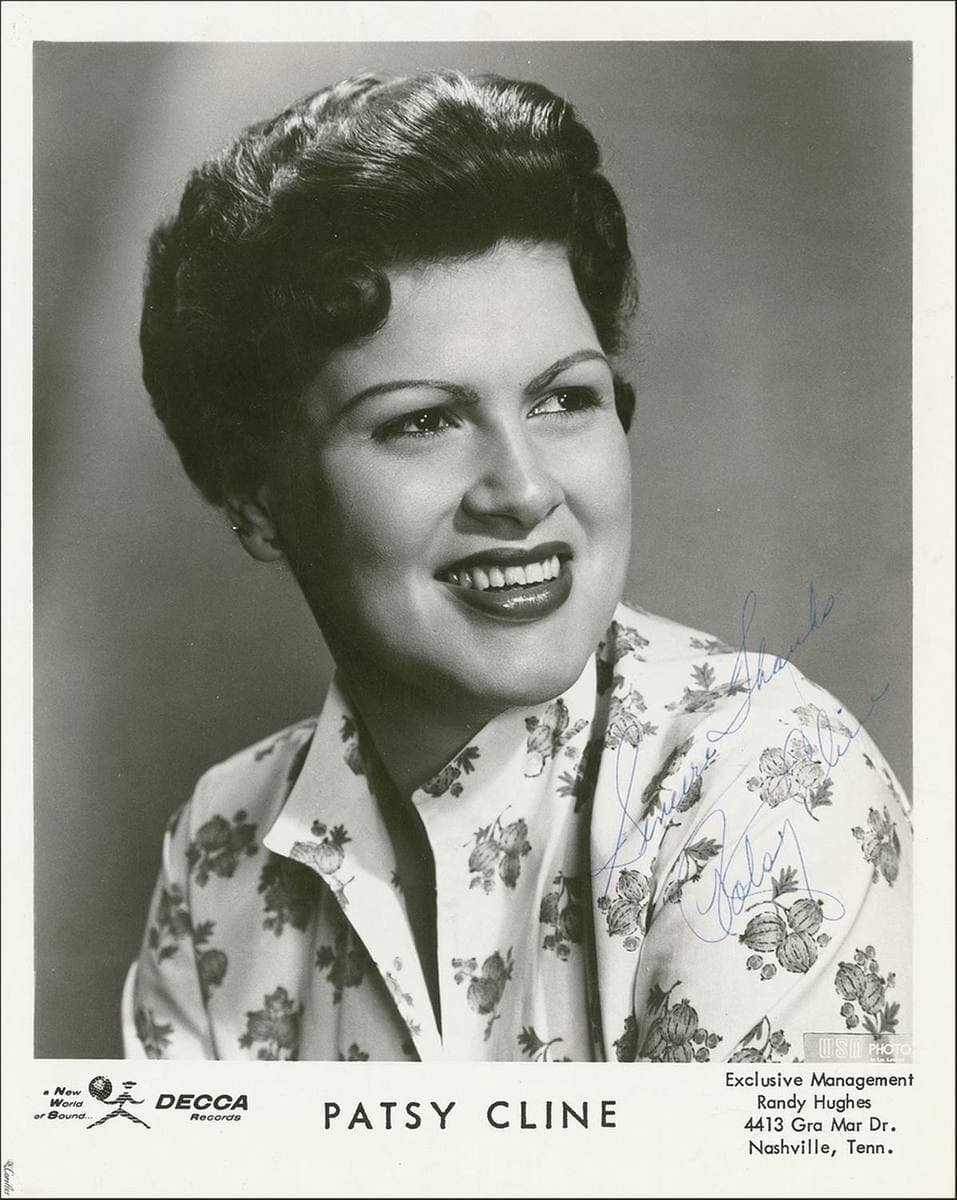 Patsy Cline in a floral blouse, smiling, her dark hair set in curls