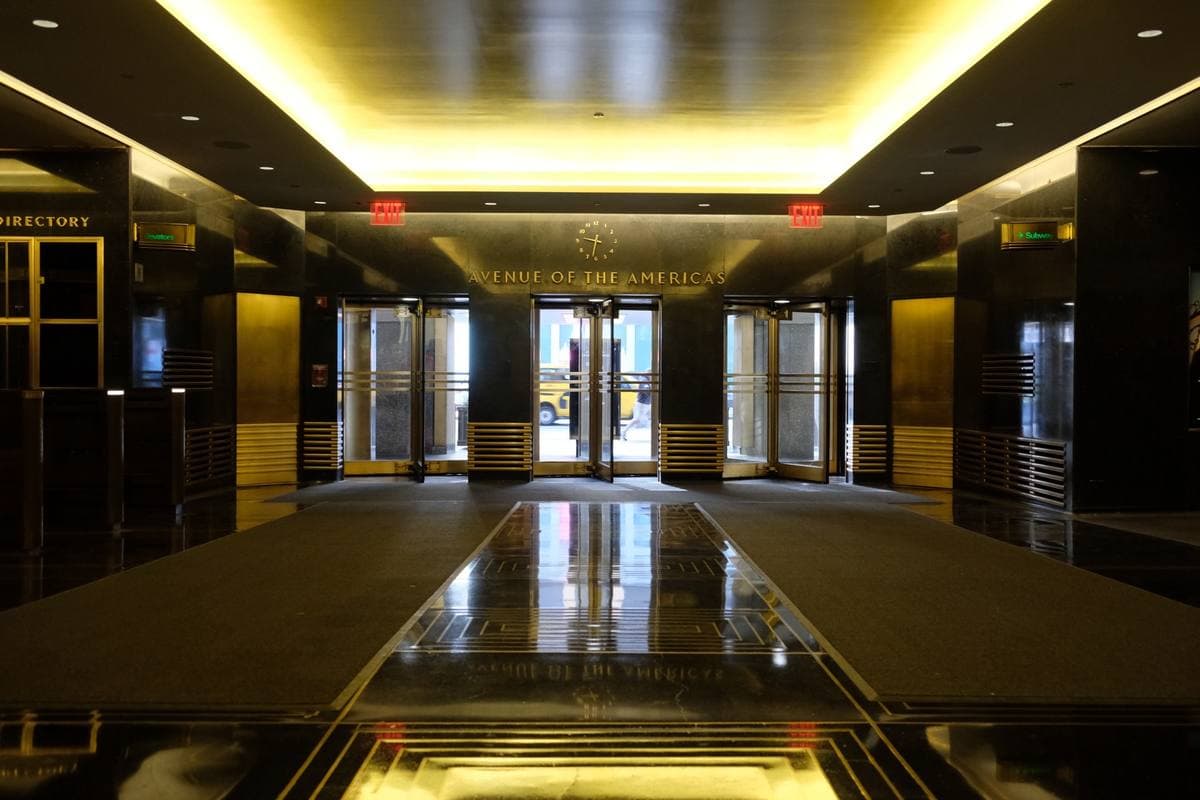 A gold-lit marble lobby leading to glass doors
