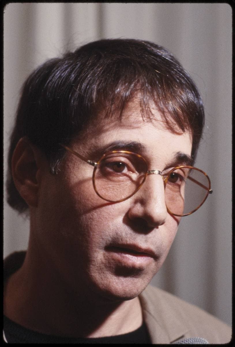 Close portrait of Paul Simon in round glasses