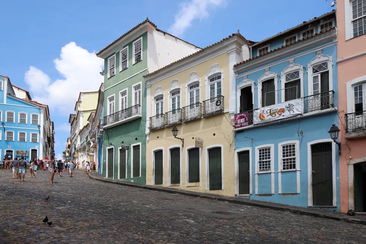 A sloping cobbled square lined with blue, yellow and pink colonial houses