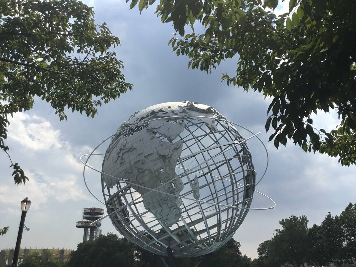 A giant steel globe framed by trees