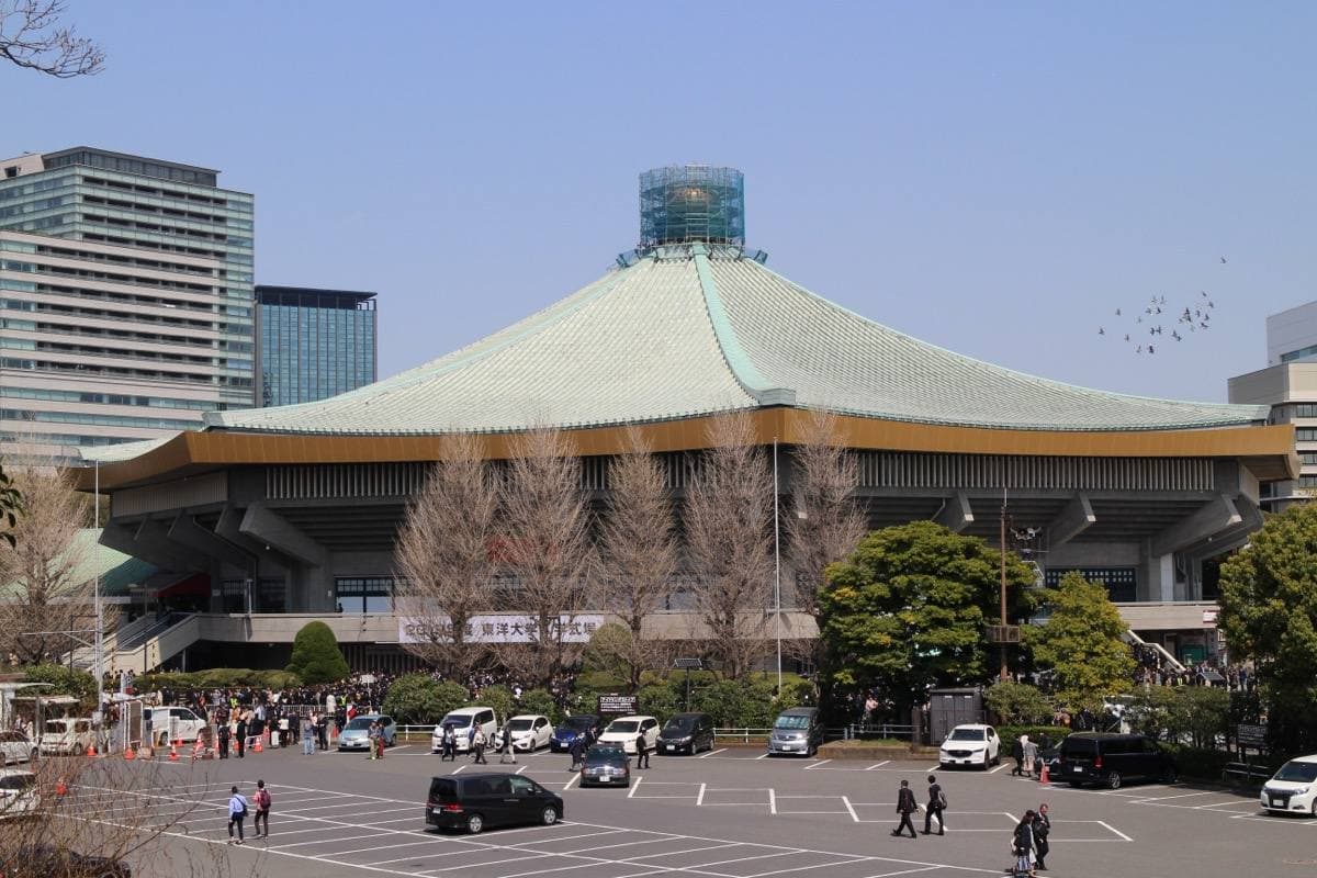 The Nippon Budokan's eight-sided roof above cherry trees