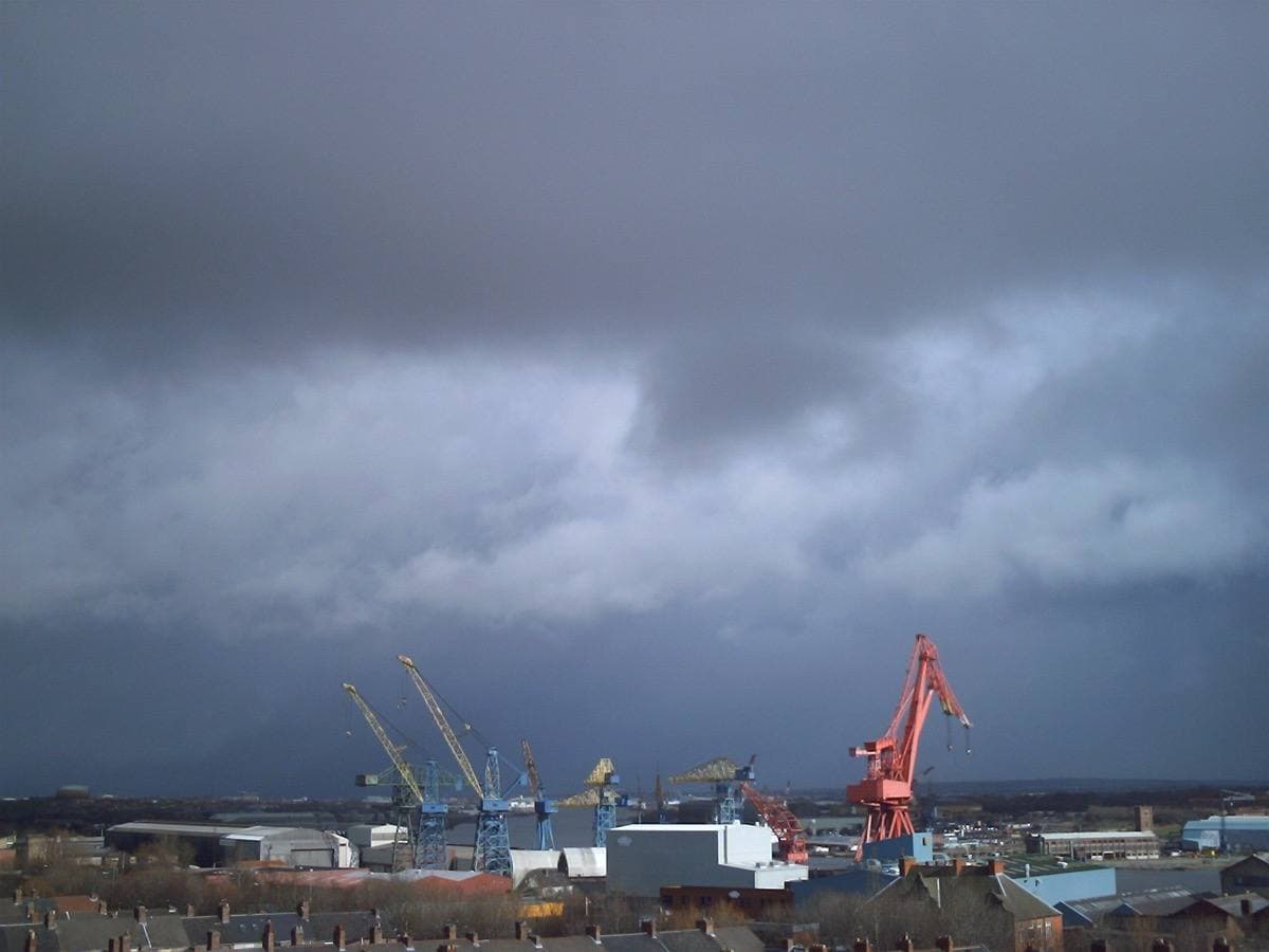 Shipyard cranes on the Tyne under a dark sky
