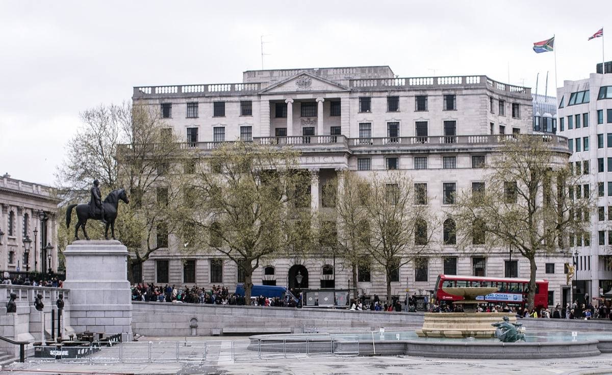 The pale stone front of South Africa House behind a Trafalgar Square fountain