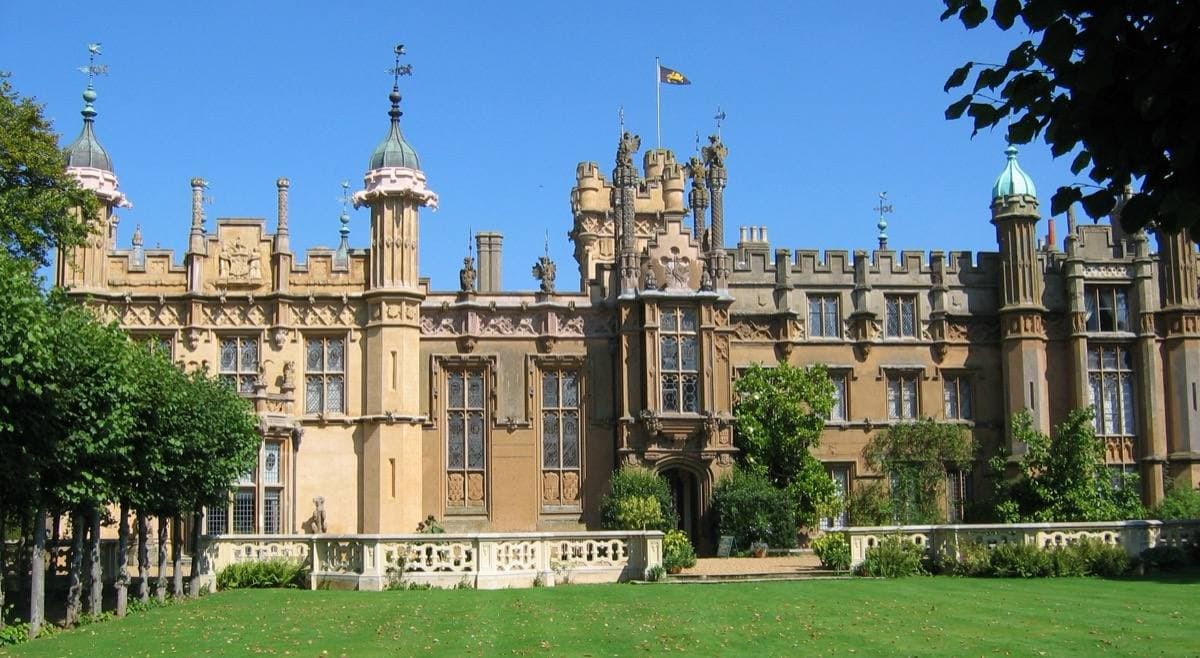 The turreted west front of Knebworth House over a lawn