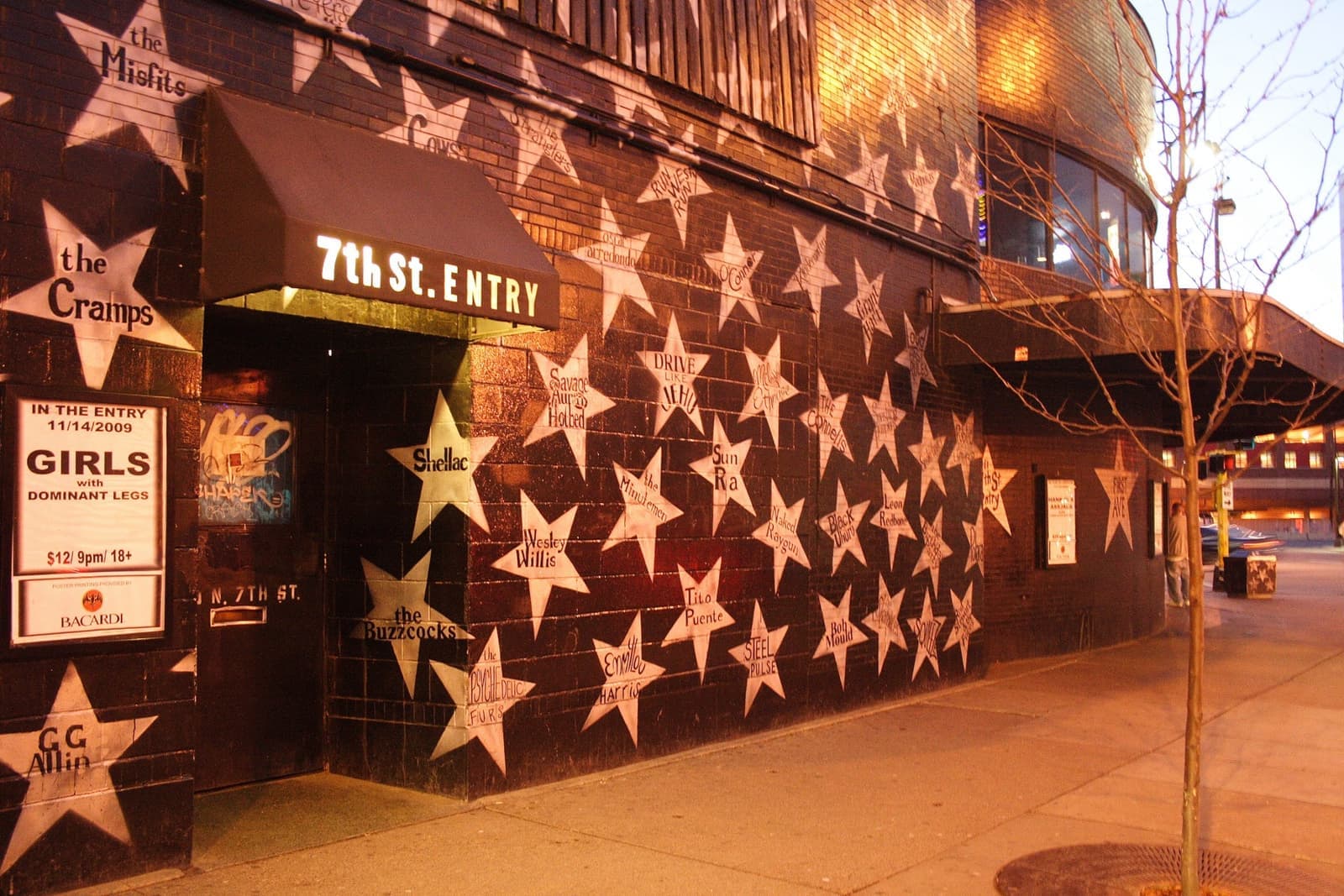 A black club exterior covered in painted white stars at dusk