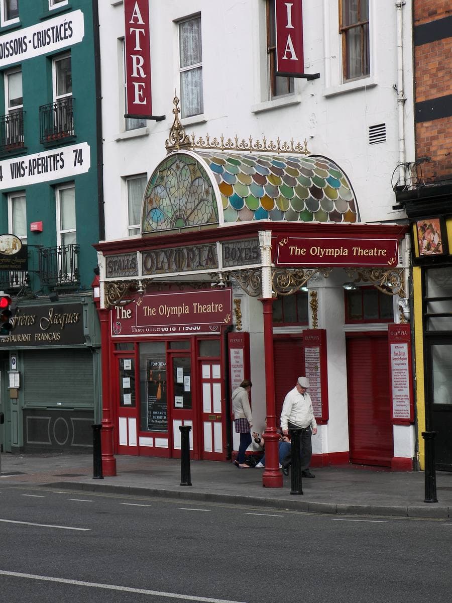 A red theatre entrance under a coloured glass and iron canopy