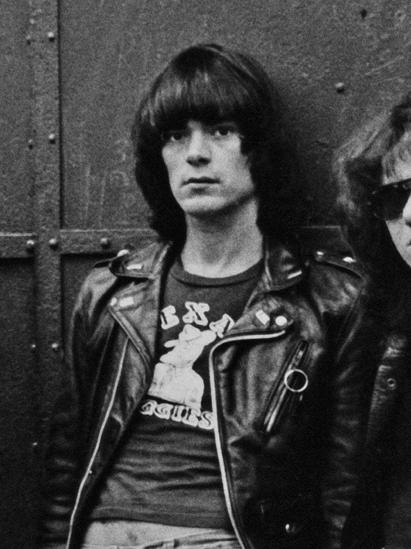 Dee Dee Ramone with a dark fringe and a printed T-shirt under a leather jacket