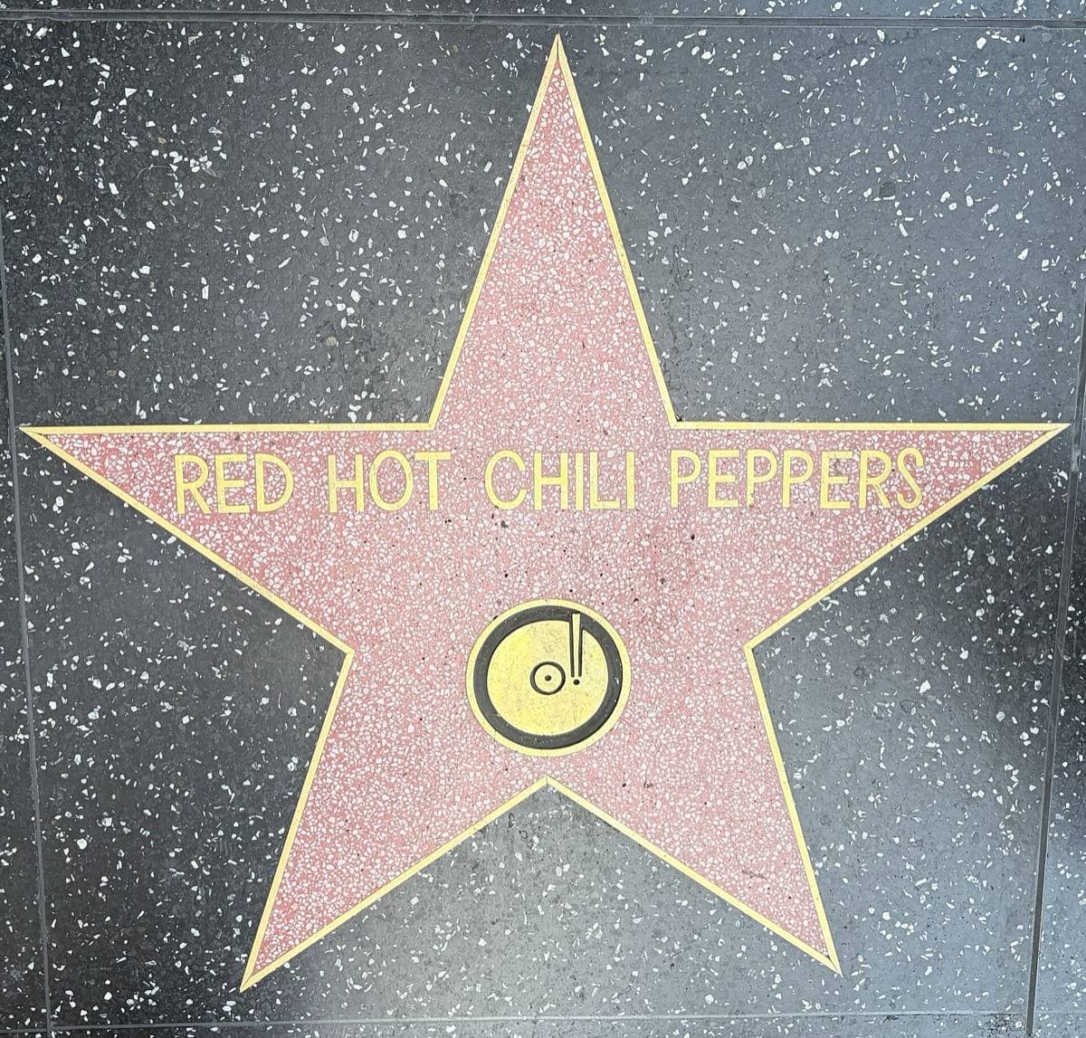 A pink terrazzo star with a brass record emblem reading Red Hot Chili Peppers