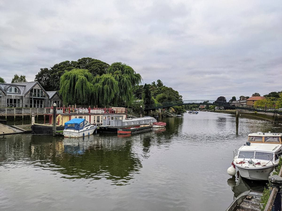 Willows and boatyards on a river island seen across the Thames