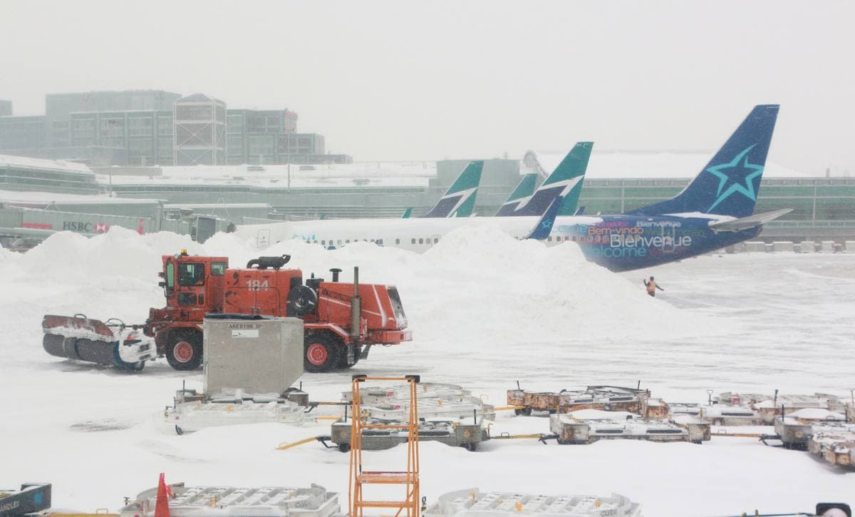 Aircraft on a snowy apron at a large airport terminal
