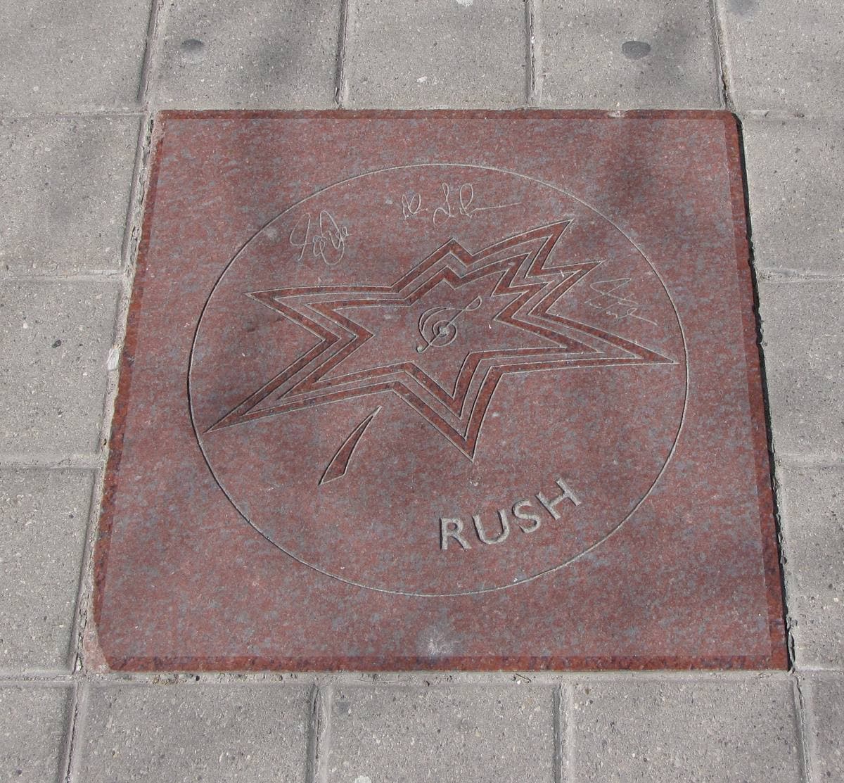 A pavement star with a maple leaf, the word Rush and three signatures