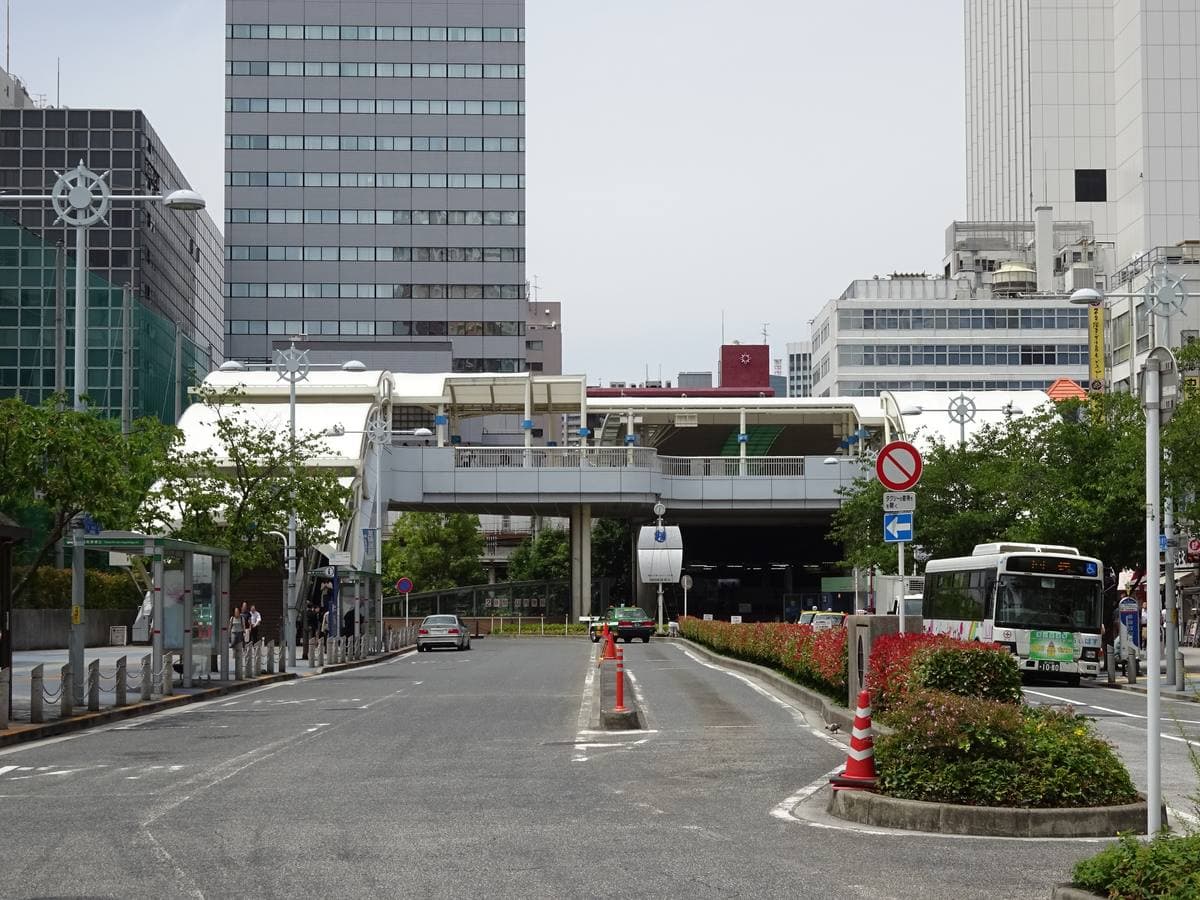A station concourse exit with a walkway and office towers