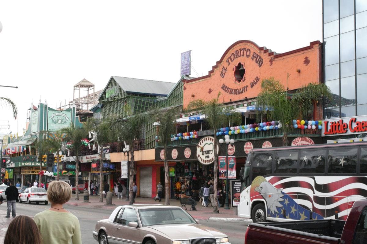 A busy Tijuana street lined with shop signs and balconies