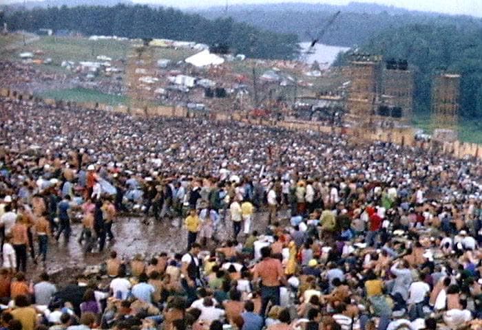 A huge crowd on a sloping field running down to a festival stage