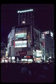 Shibuya crossing at night in 1992, neon signs and traffic lights over the road
