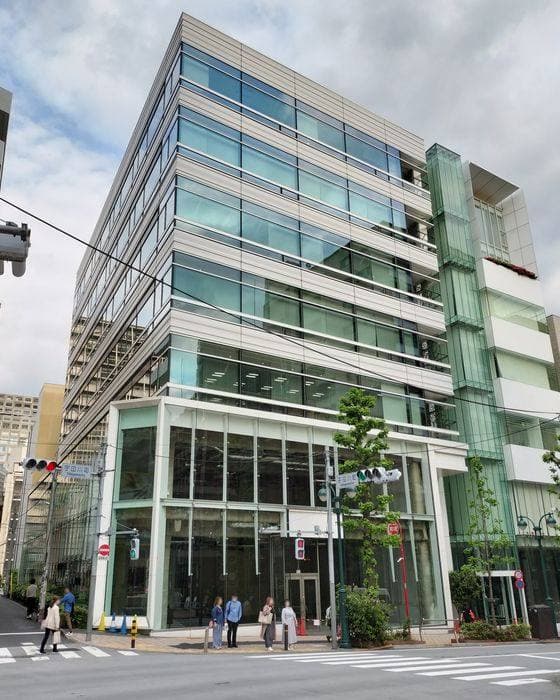 A glass office building on a street corner at the Udagawacho crossing