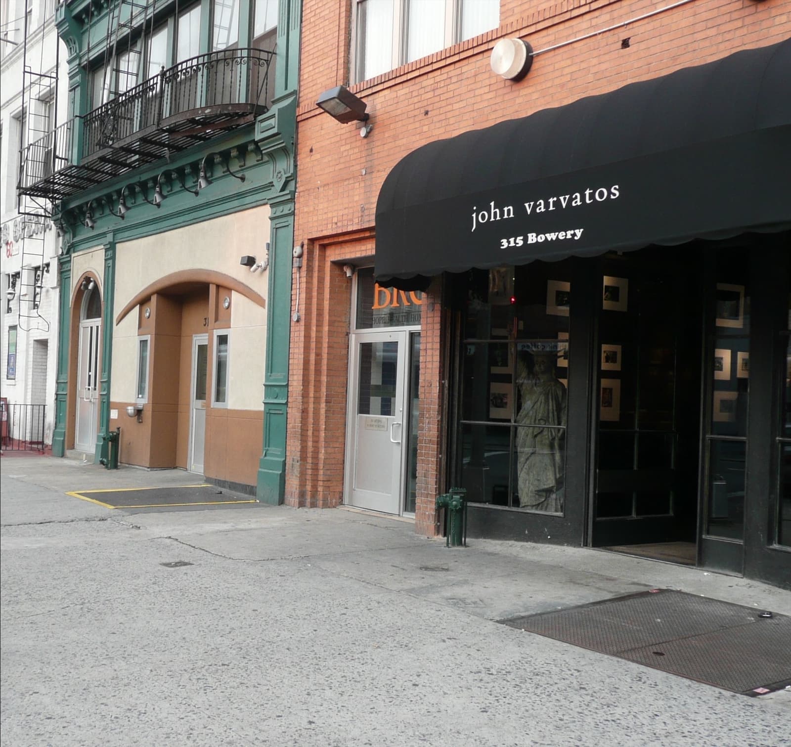 A shopfront with a black awning on a pale building on the Bowery