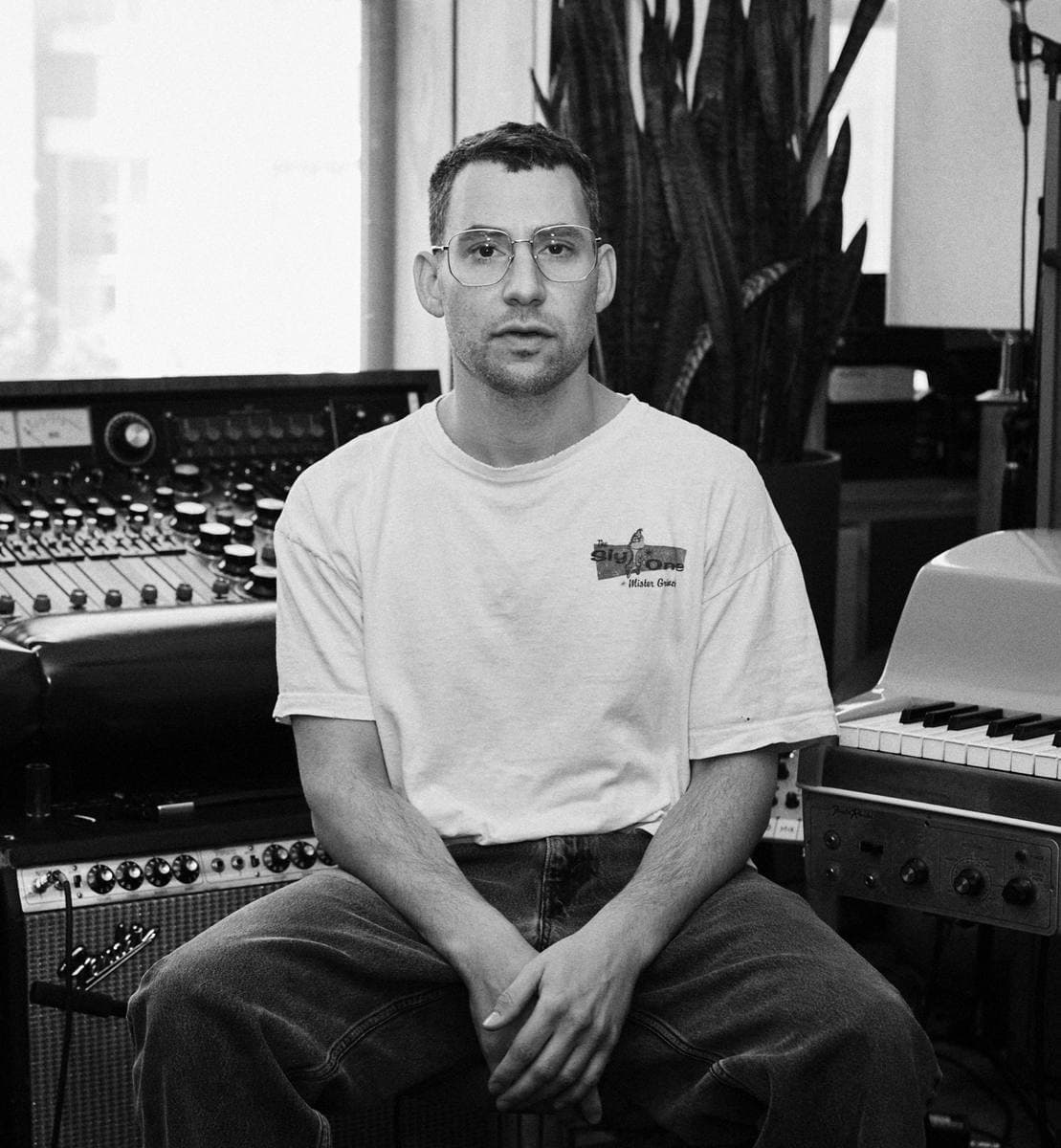 Jack Antonoff seated beside a mixing desk, in black and white