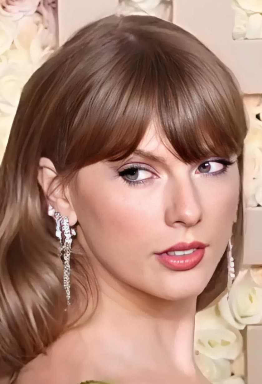 Taylor Swift in profile, hair swept back, with long drop earrings