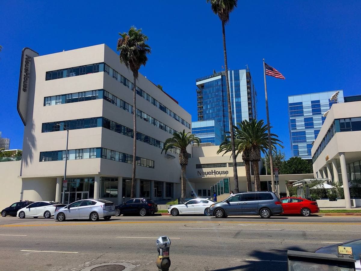 A white modernist building with long horizontal bands of windows on Sunset Boulevard