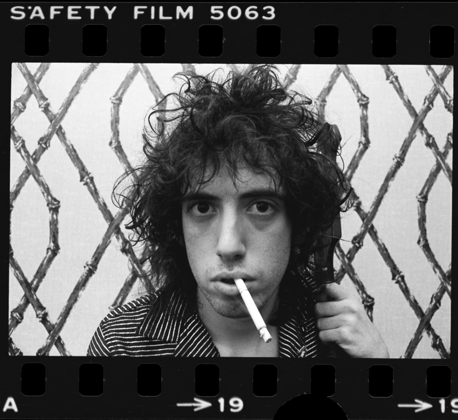 Mick Jones with a cigarette and a telephone receiver, on a contact-sheet frame