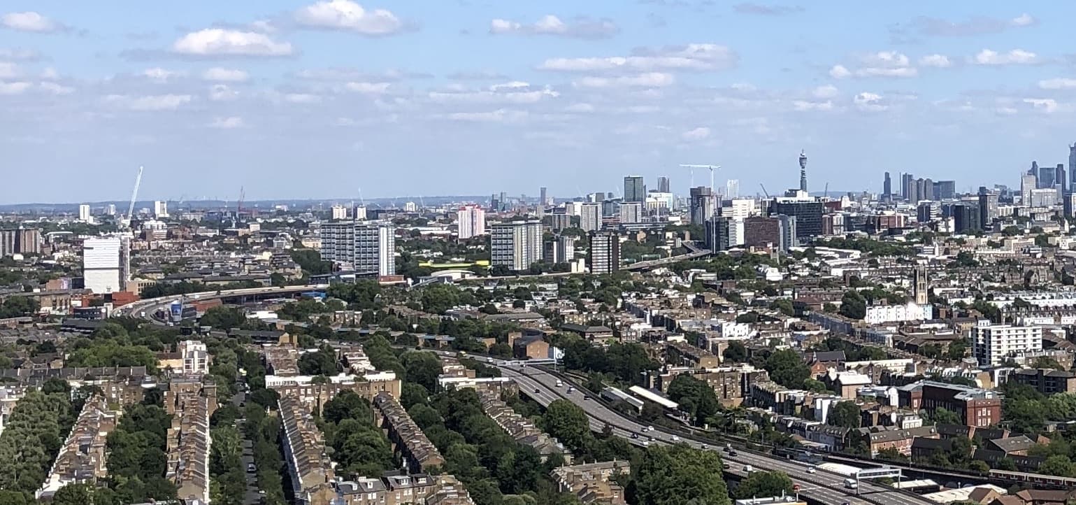 A wide view of west London roofs with the motorway running towards the City