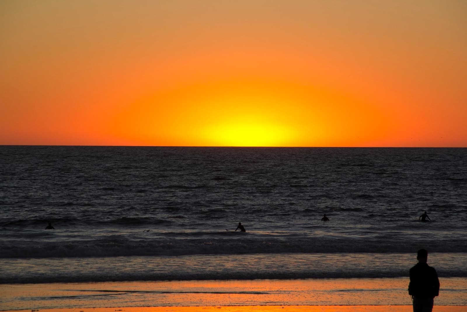 The sand at Venice Beach with the sun low over the Pacific