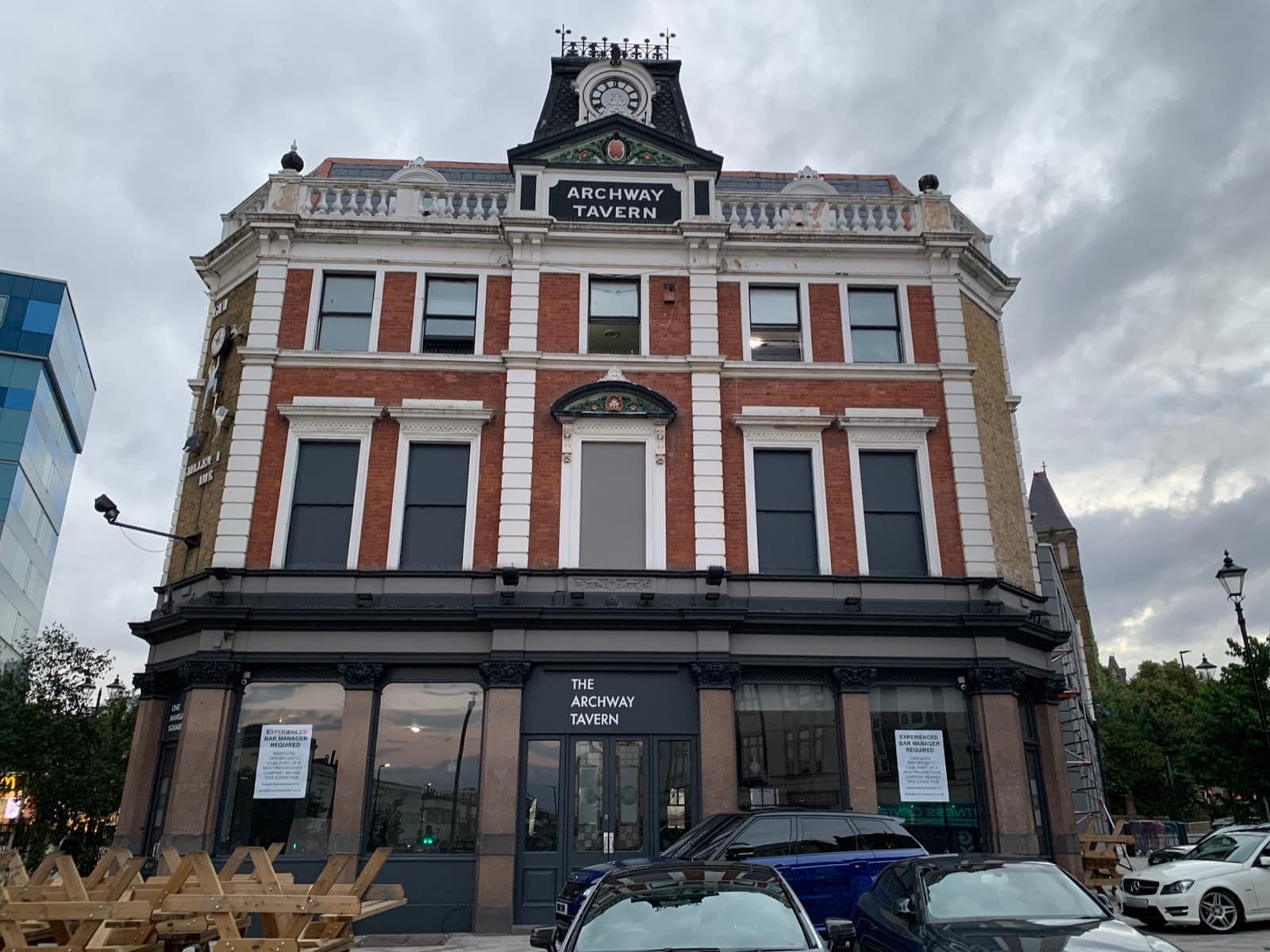 A tall red-brick Victorian pub with a clock and the words Archway Tavern at the top
