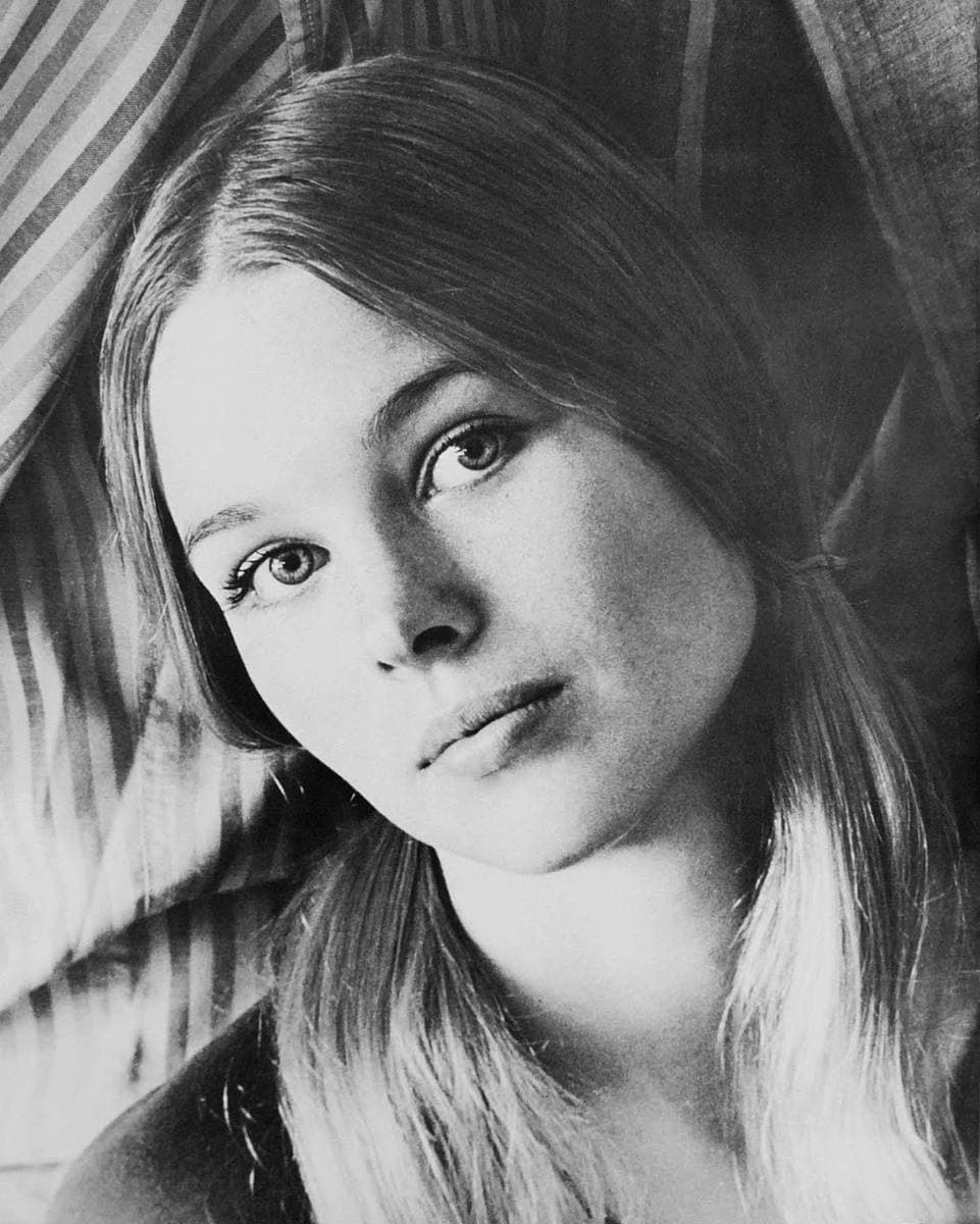 A black-and-white head-and-shoulders portrait of a young woman with long fair hair