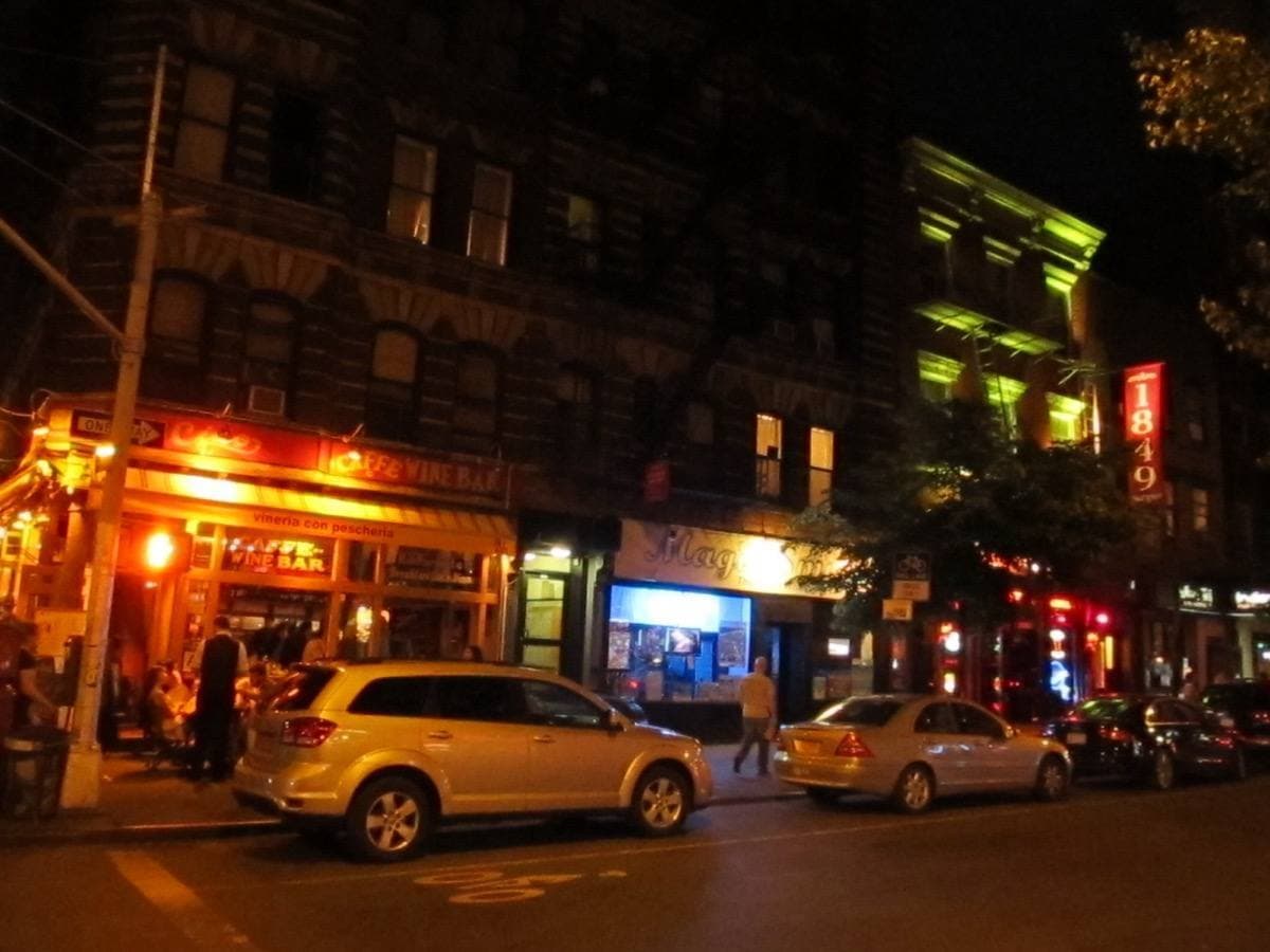 A Greenwich Village street of low brick buildings with shop fronts